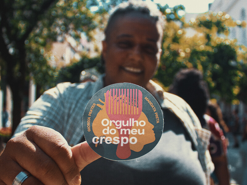 Giorgia Prates segurando uma placa com a frase Orgulho do meu crespo