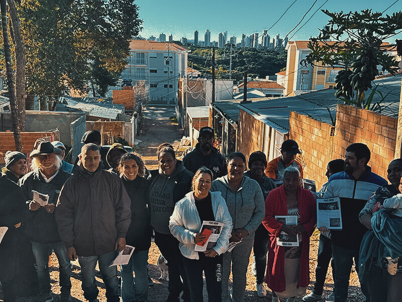 Giorgia Prates com um grupo de moradores em uma comunidade